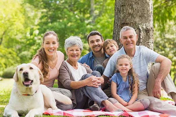 Multi-generational family enjoying a picnic in the park.